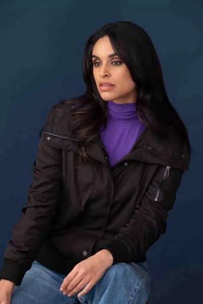 Manteau avec fronces, col montant et capuche, porté avec un haut violet et jean, look urbain.