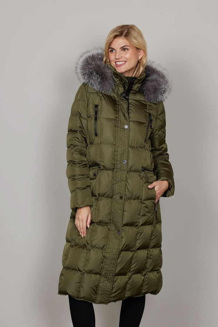 Manteau à capuche avec fourrure, long matelassé, protection contre le froid, femme portant un manteau vert avec capuche bordée de fourrure synthétique.