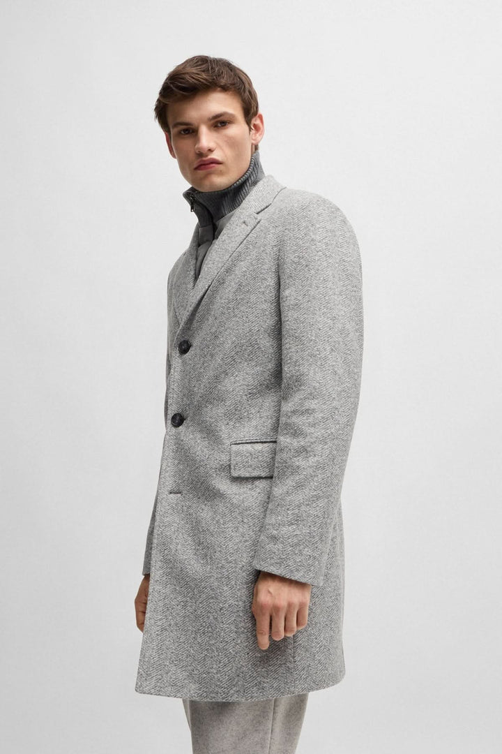 Manteau à chevrons gris pour homme avec fermeture amovible, style élégant et coupe ajustée.