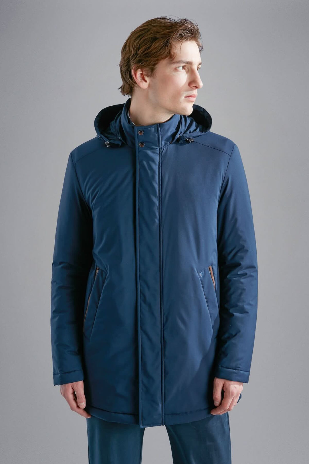 Manteau d'hiver bleu marine avec capuche ajustable et poches zippées, idéal pour jours froids.