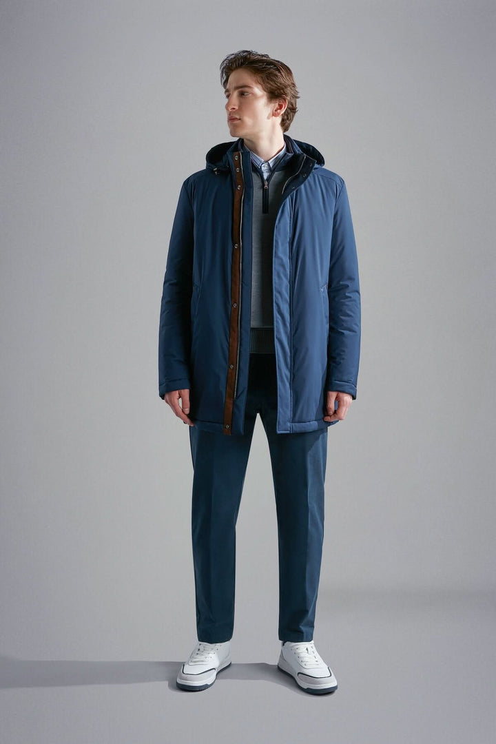 Homme portant un manteau d'hiver bleu marine avec capuche, idéal pour les journées froides.