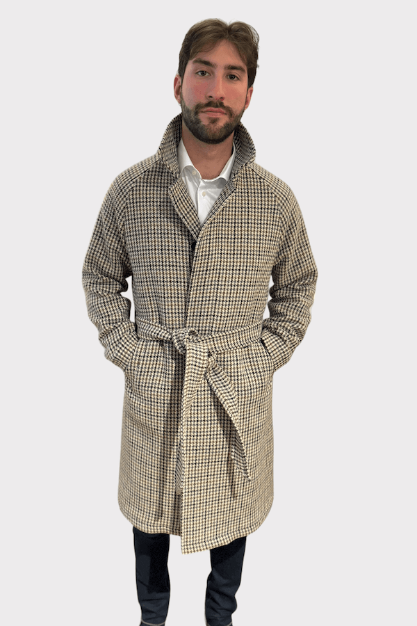 Homme portant un manteau en tweed à motif pied-de-poule, au style élégant et intemporel.
