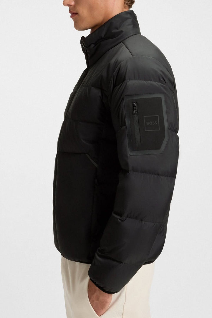 Manteau matelassé déperlant en duvet avec poche sur la manche par BOSS, noir, coupe droite, idéal pour la mi-saison.