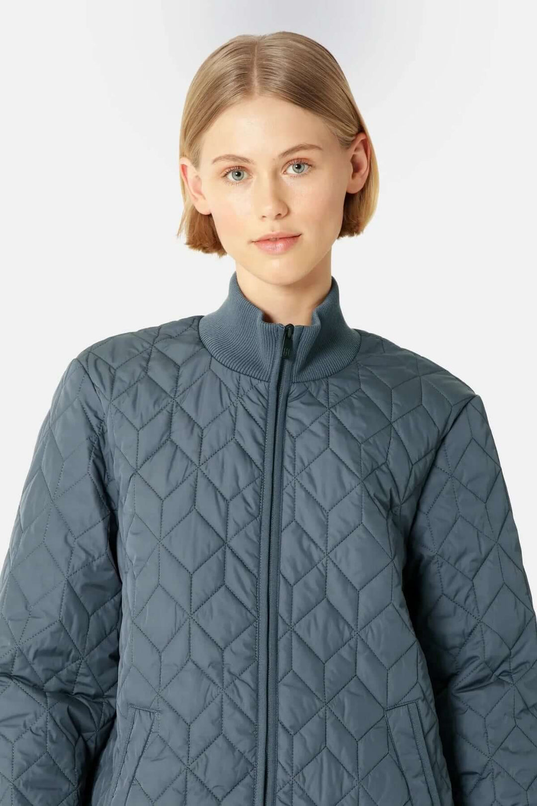 Femme portant un manteau matelassé long à col montant avec motifs géométriques.
