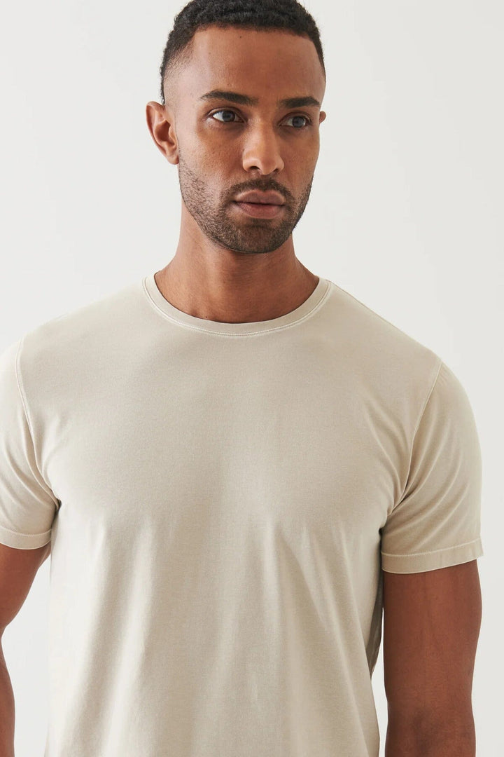 Homme portant un t-shirt stretch vintage à manches courtes sur fond neutre, mettant en avant sa texture en coton.