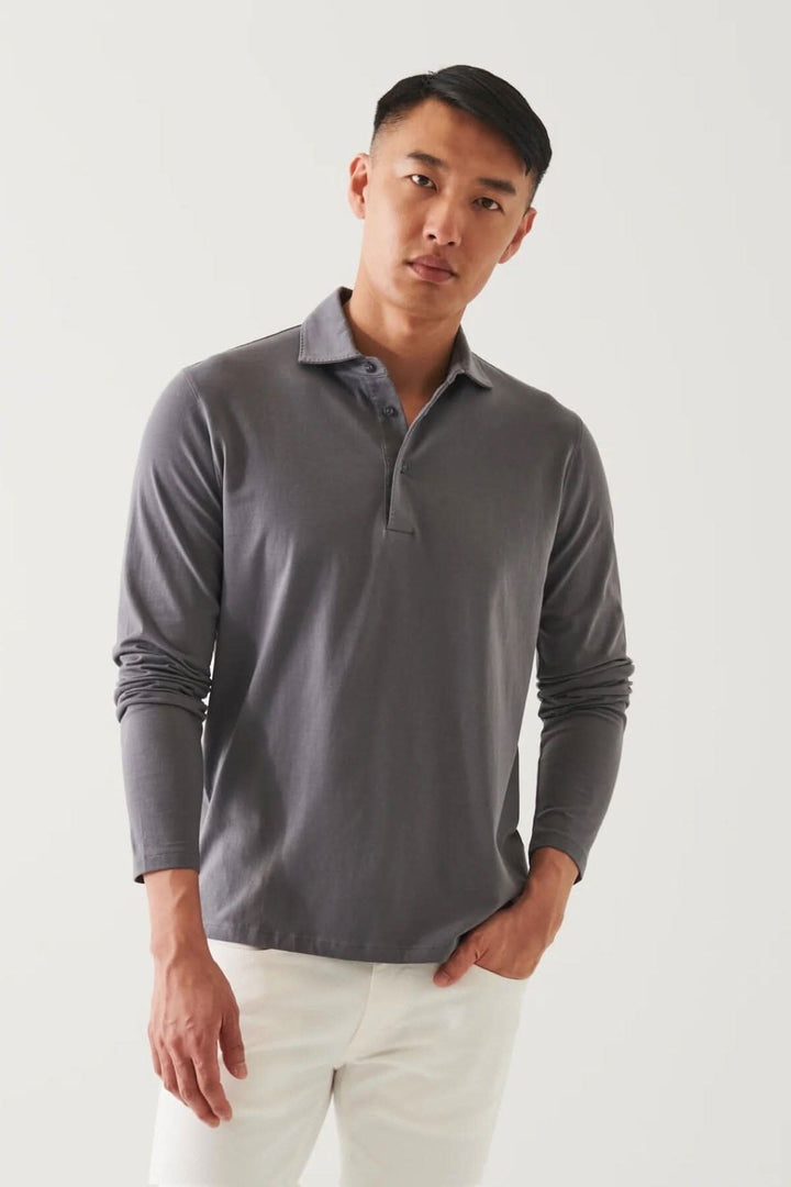 Polo en coton stretch à manches longues, col surpiqué, porté par un homme, style décontracté ou habillé.