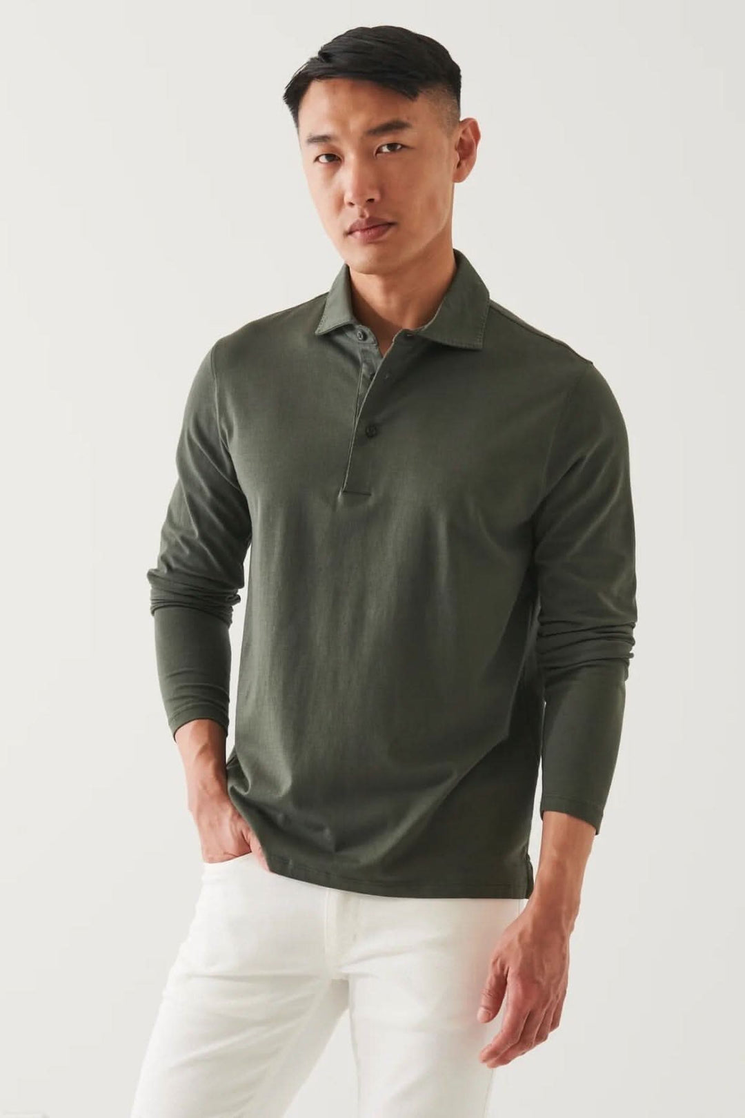 Homme portant un polo à manches longues en coton stretch vert, style décontracté et élégant.