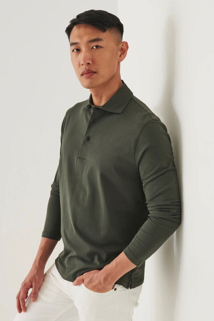 Polo à manches longues en coton pima, col surpiqué, porté de manière décontractée par un homme.