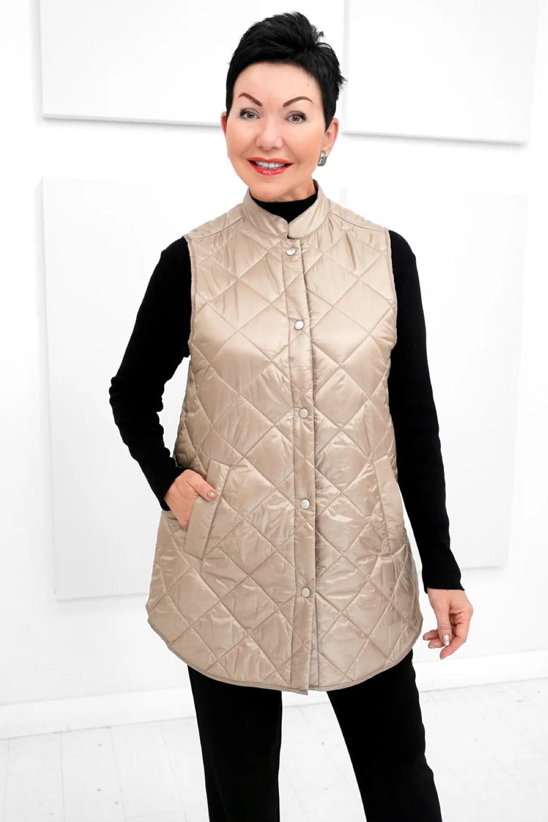 Femme portant un gilet matelassé beige Ilse Jacobsen, élégant et léger, sans capuche, avec boutons-pression.
