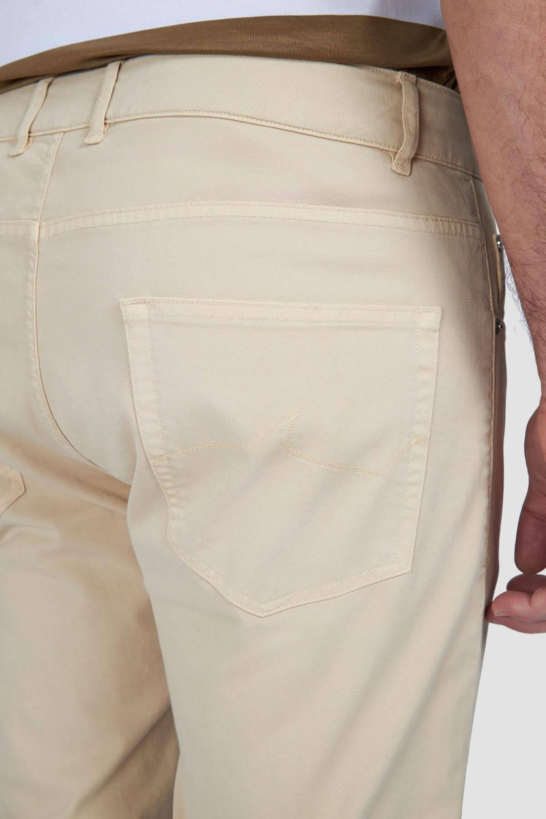 Détail arrière d'un pantalon chino beige en coton, montrant la coupe ajustée et la poche.