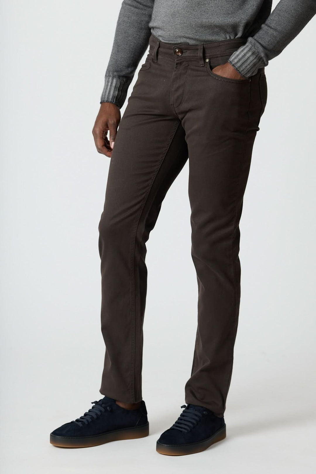 Homme portant un pantalon 5 poches en sergé coton-lyocell noir avec un pull gris, de coupe ajustée et élégance italienne.