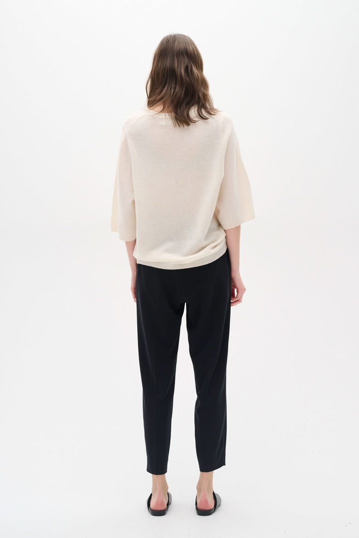 Femme vue de dos portant un ensemble chic avec pantalon Adian, tissu confortable et taille élastique.