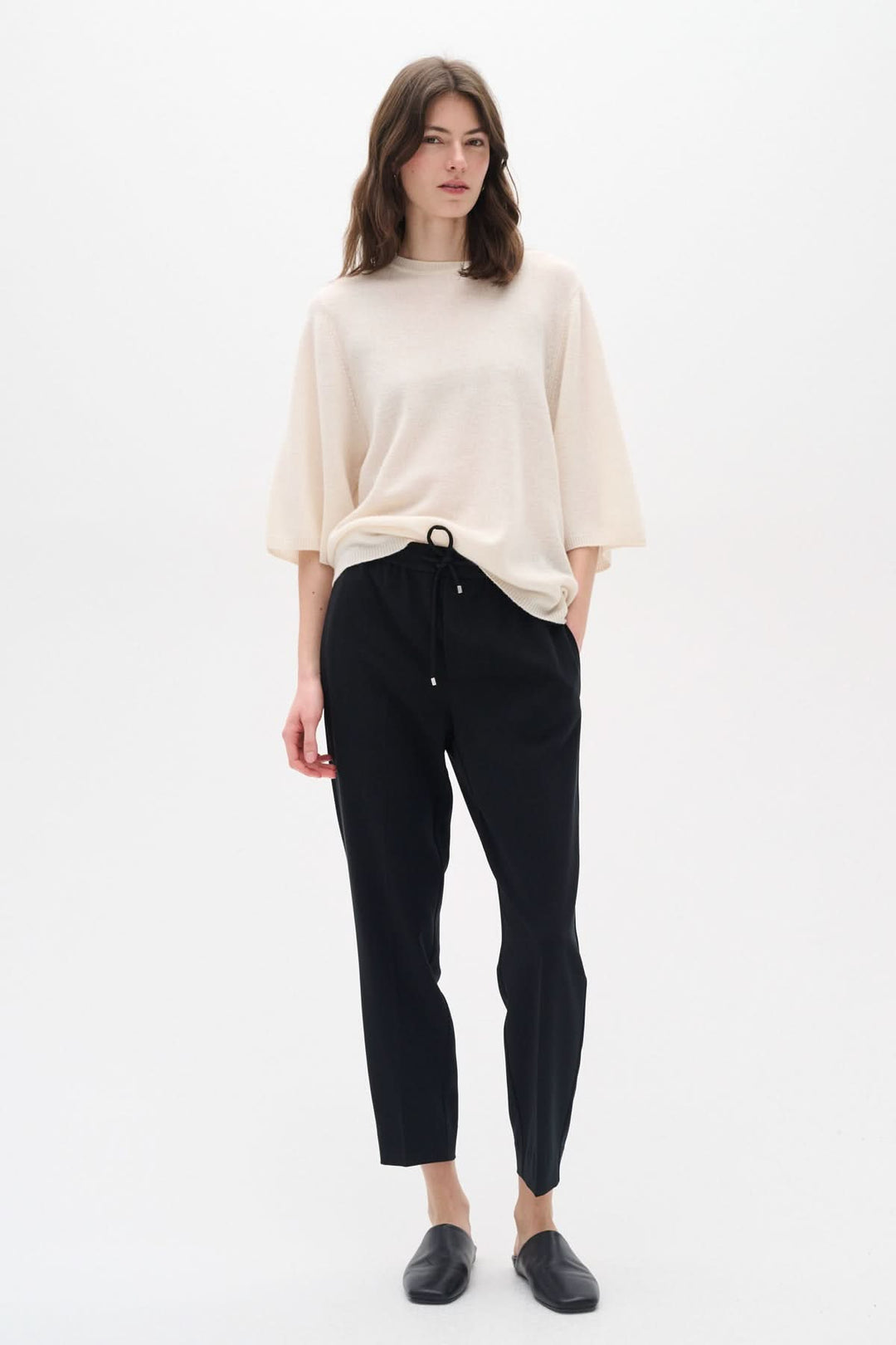 Femme portant le pantalon Adian avec un haut beige, offrant un look chic et décontracté.
