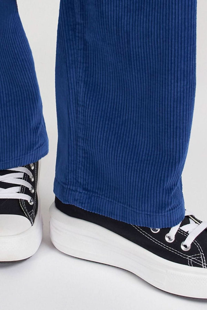 Détails du pantalon Baltimore en velours bleu, associé à des chaussures noires pour un look décontracté et tendance.