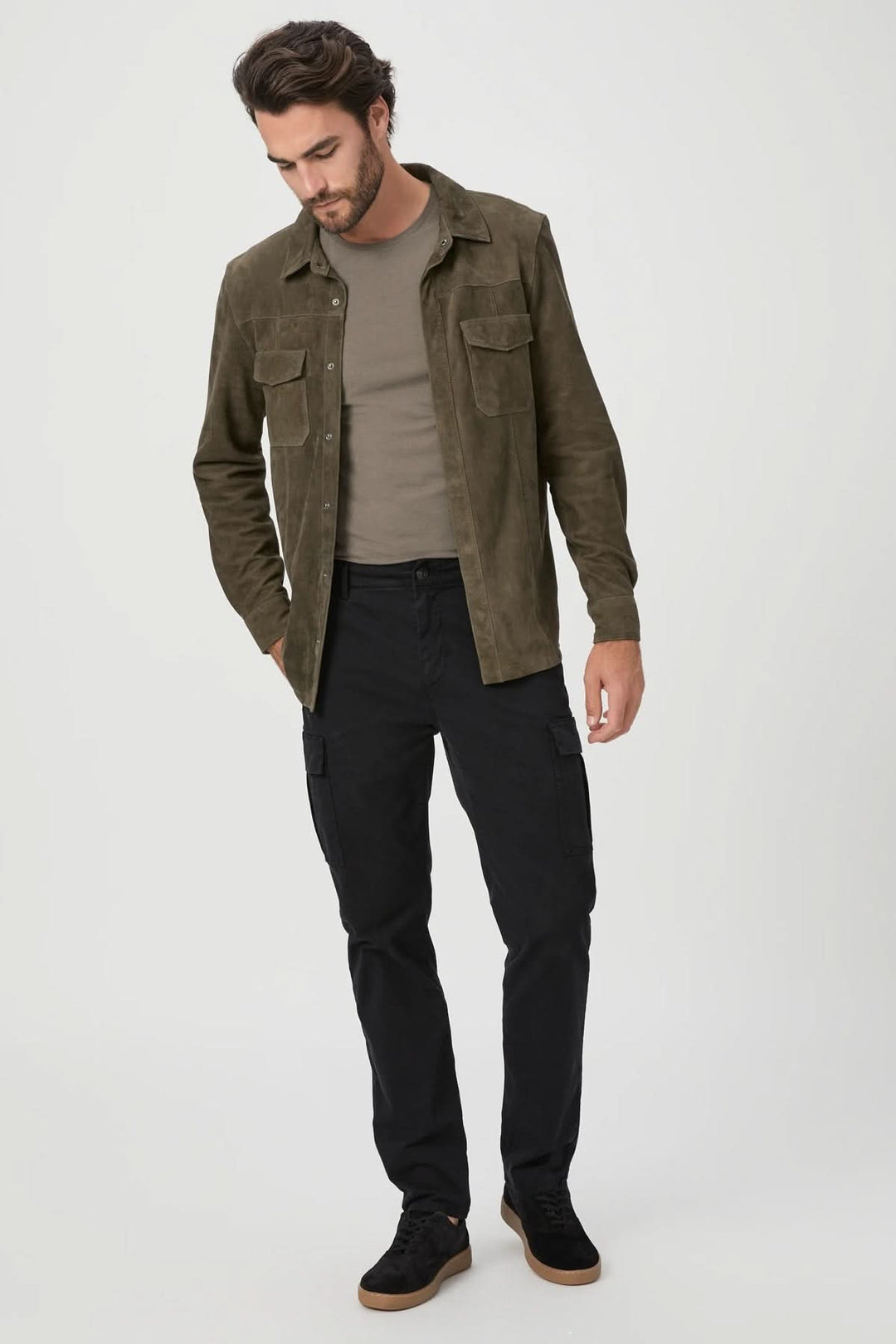 Homme portant une chemise en daim olive et un pantalon cargo noir avec des poches, dans un look décontracté.