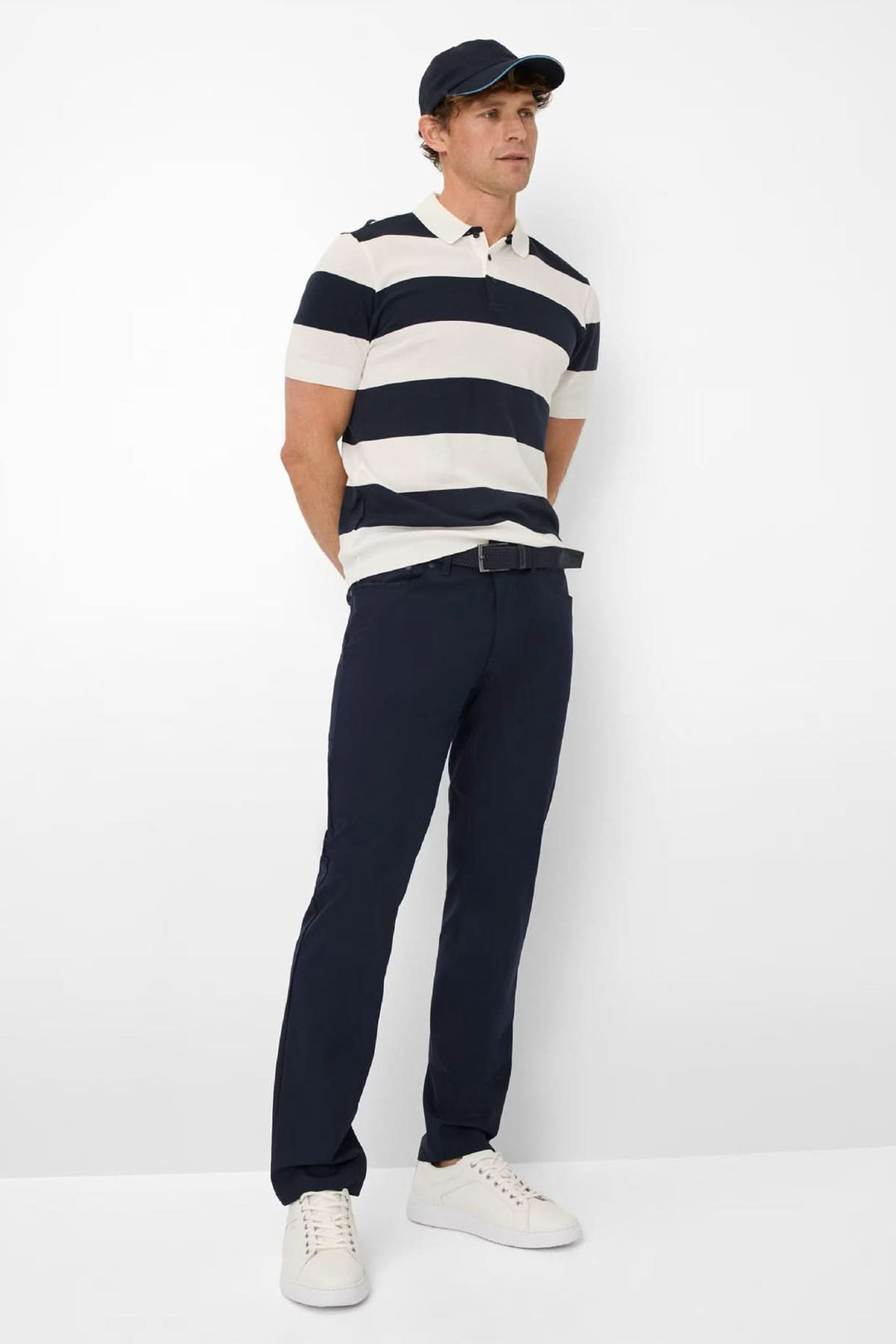 Homme portant le Pantalon Chuck coupe droite, style moderne et décontracté, avec polo rayé et casquette.