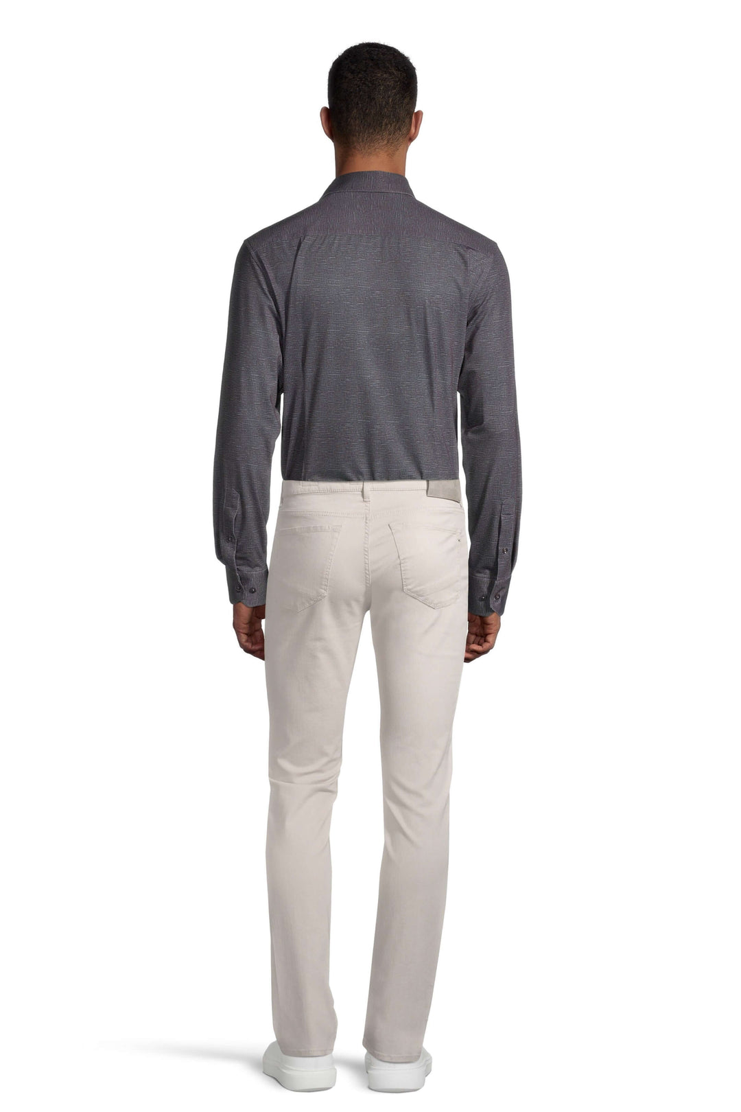 Homme portant une chemise grise et un pantalon beige, vue de dos, style moderne et décontracté.