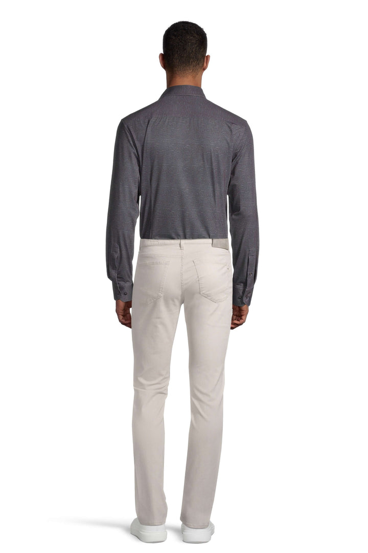 Homme portant une chemise grise et un pantalon beige, vue de dos, style moderne et décontracté.