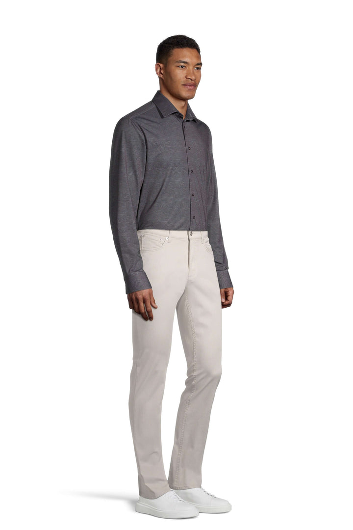 Homme portant un pantalon Hi-Flex Chuck beige avec une chemise grise, style moderne et décontracté.