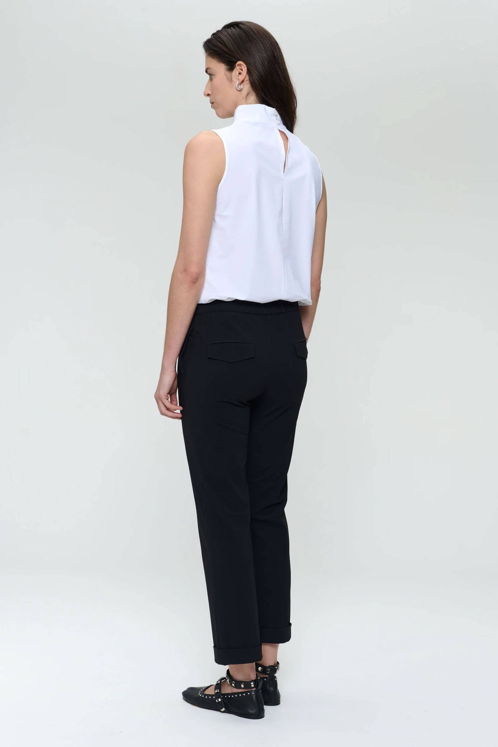 Femme vue de dos portant un pantalon Irena noir avec une blouse blanche, alliant élégance et confort.