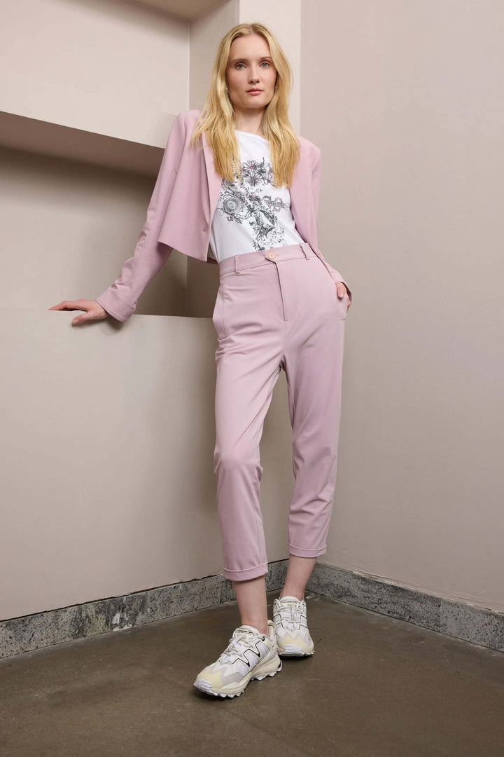 Femme en pantalon 7/8e rose avec veste assortie, favorisant un style moderne et décontracté.