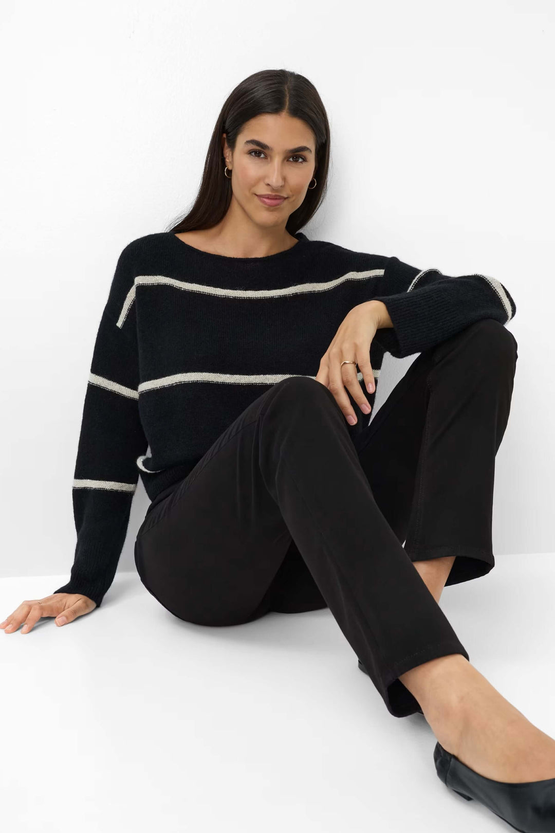 Femme portant un Pantalon Mary coupe droite avec chandail ample et chaussures plates pour un look élégant et confortable.