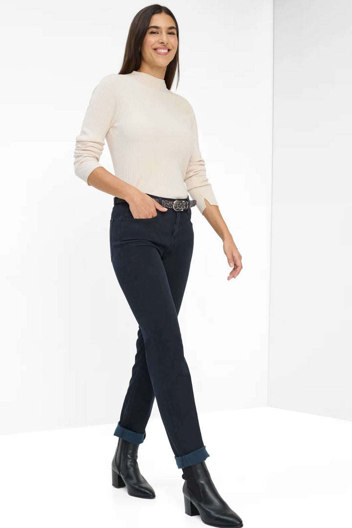 Pantalon Mary avec coupe droite classique, porté avec un chandail blanc et des bottines pour un style élégant et confortable.
