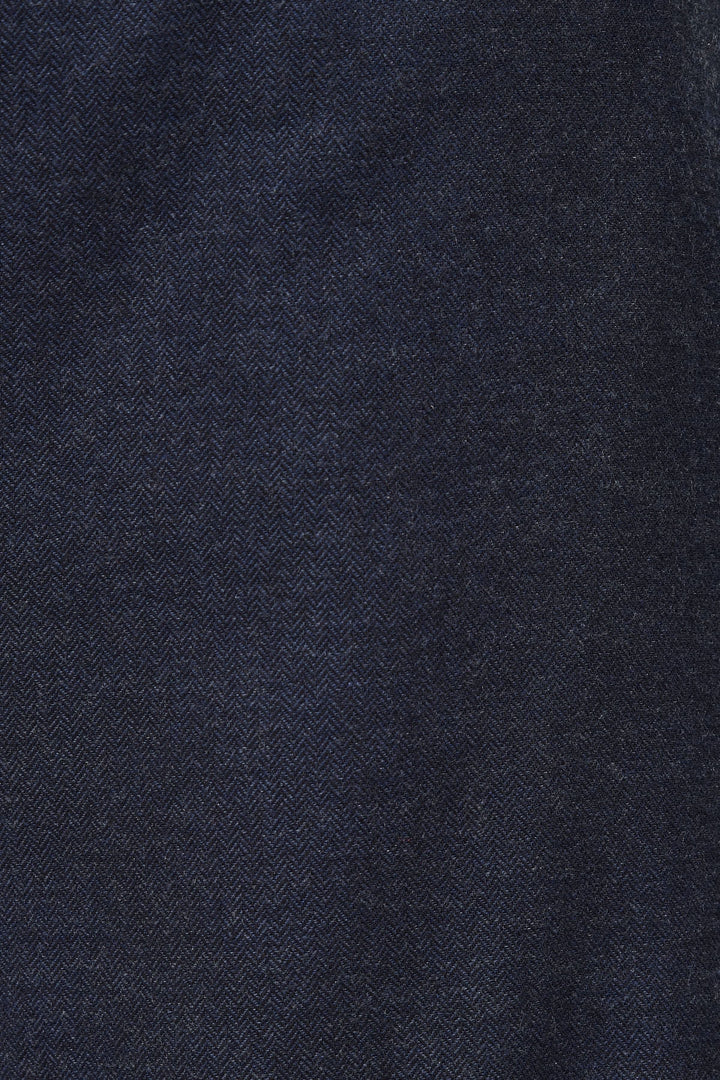 Tissu en denim bleu foncé avec motif en chevron, parfait pour des pantalons modernes et stylés.