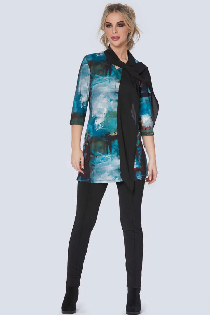 Modèle féminin portant une tunique bleue à imprimé artistique avec un pantalon slim noir.