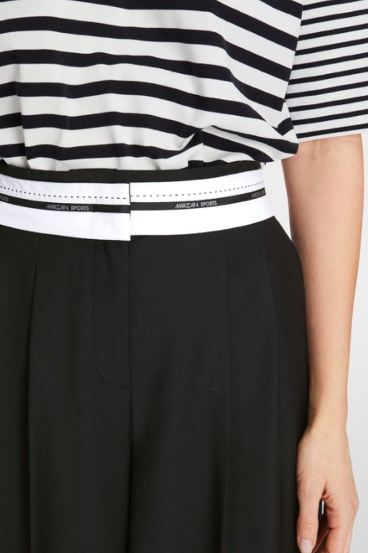 Détail du pantalon WICHITA avec ceinture blanche et haut rayé noir et blanc pour une tenue élégante.