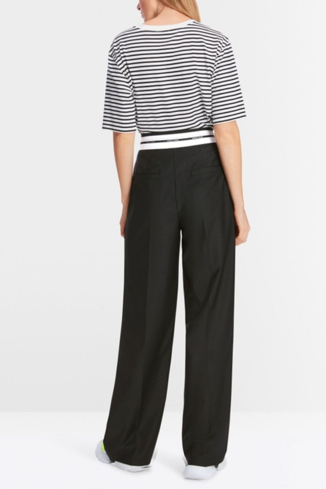 Femme portant un pantalon fluide WICHITA à jambe large, vu de dos, associé à un t-shirt rayé.