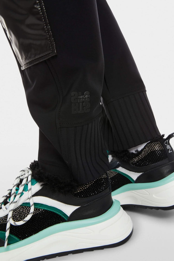 Pantalon avec poches à rabat et empiècements côtelés, porté avec des baskets modernes.