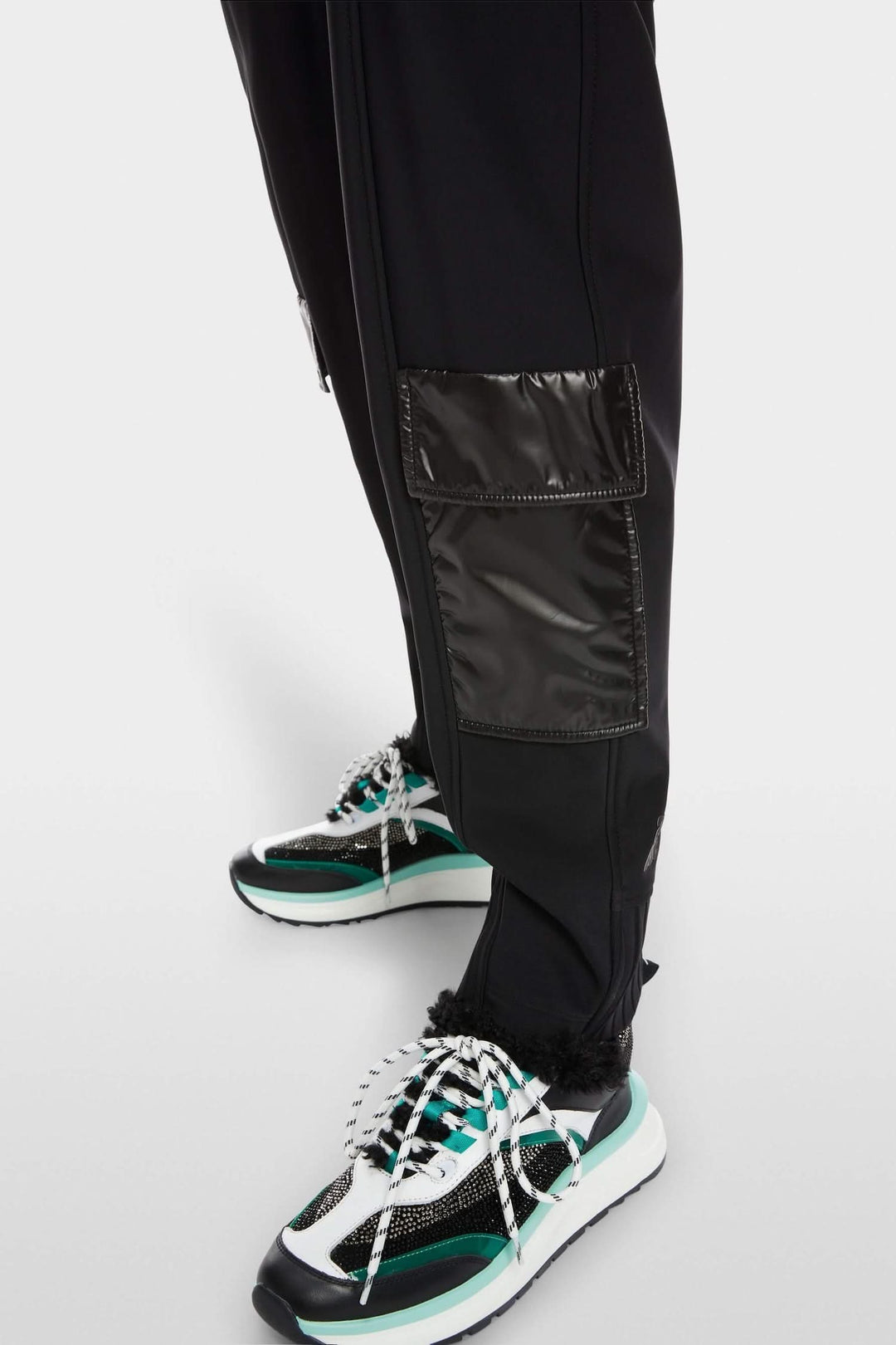 Pantalon RIETI noir avec poches en nylon et empiècements côtelés, porté avec des sneakers tendance.
