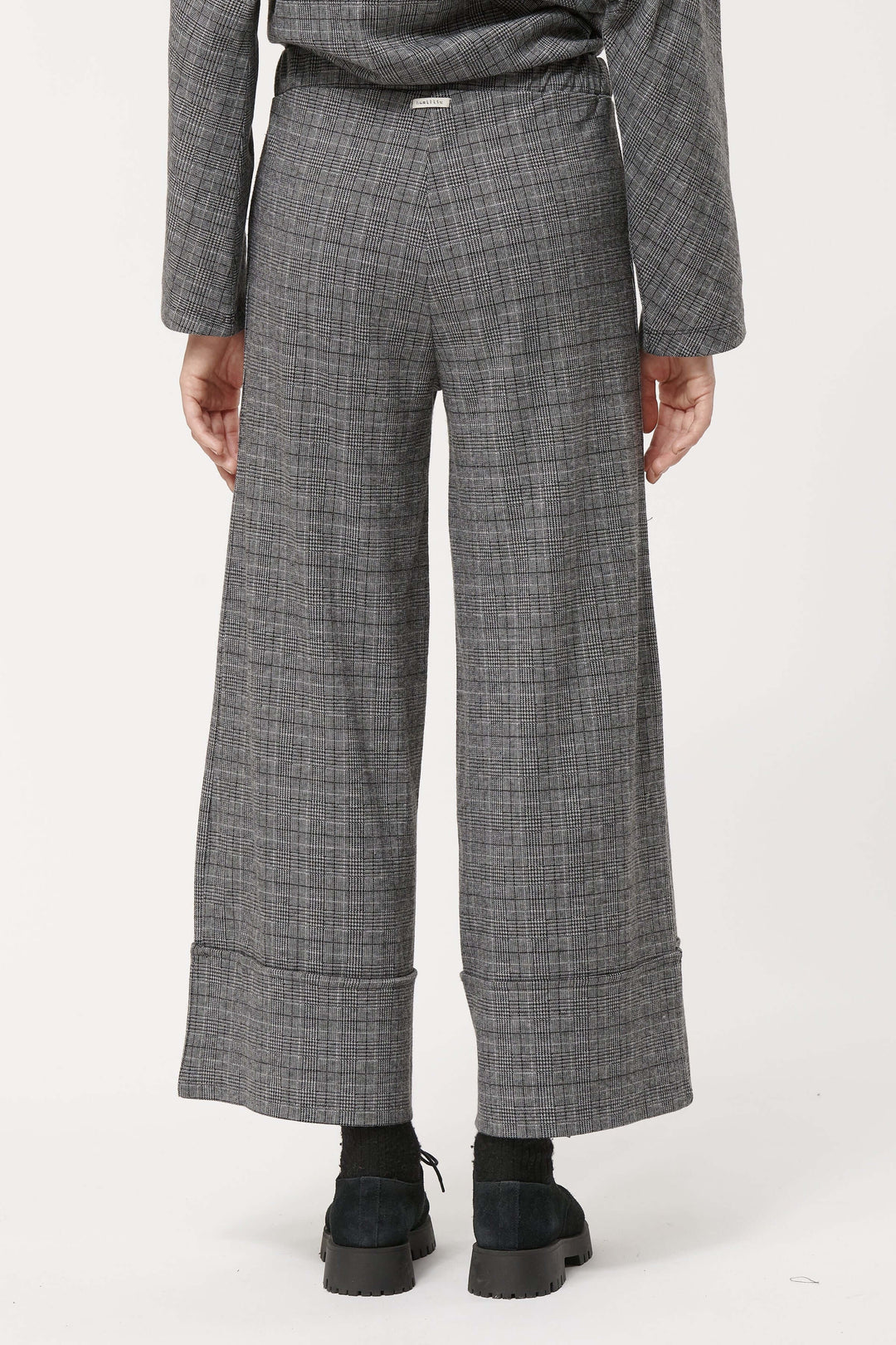 Pantalon à carreaux élégant avec taille haute et coupe large, vue arrière sur modèle.