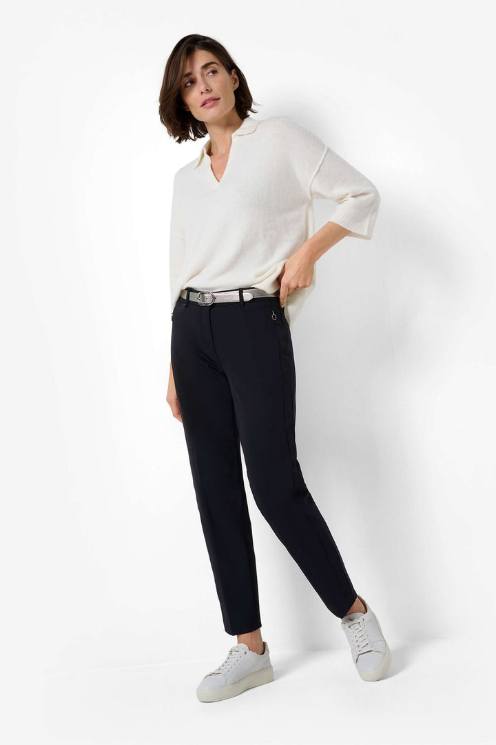 Femme portant un pantalon chino Maron S avec un pull blanc, idéal pour un look décontracté et élégant.