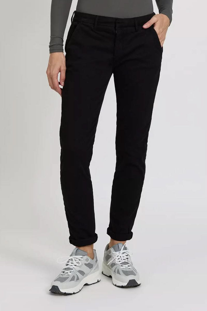 Pantalon chino Sandy noir porté avec des sneakers, mettant en avant une coupe élégante et décontractée.
