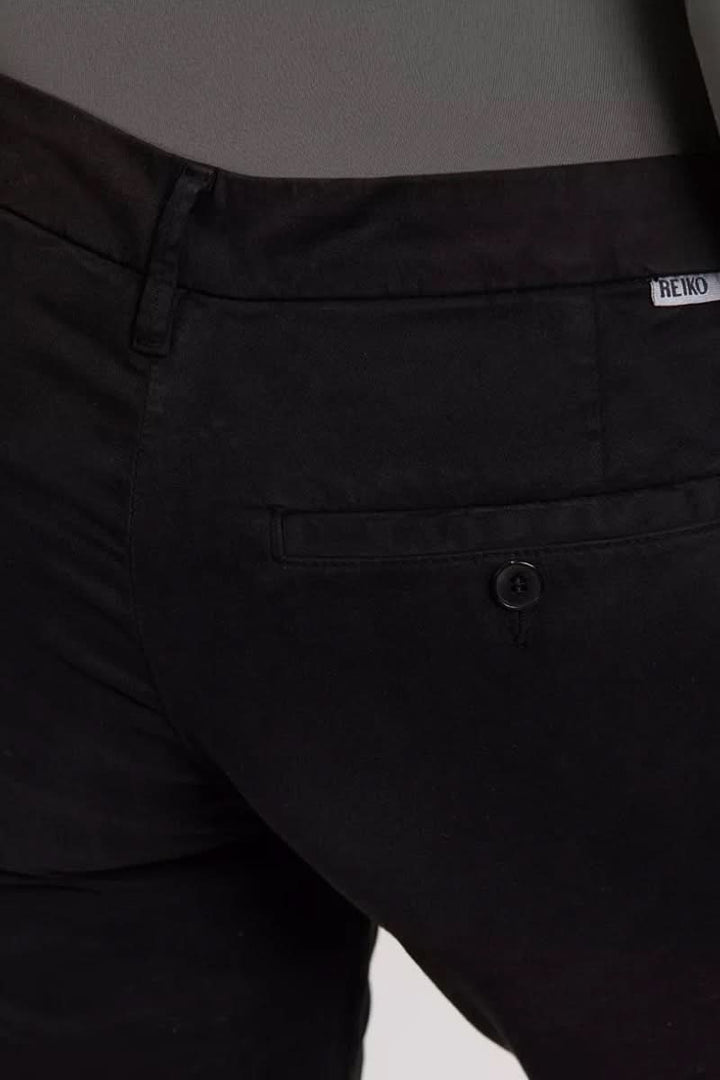 Pantalon chino Sandy noir avec poches passepoilées arrière, style décontracté et chic.