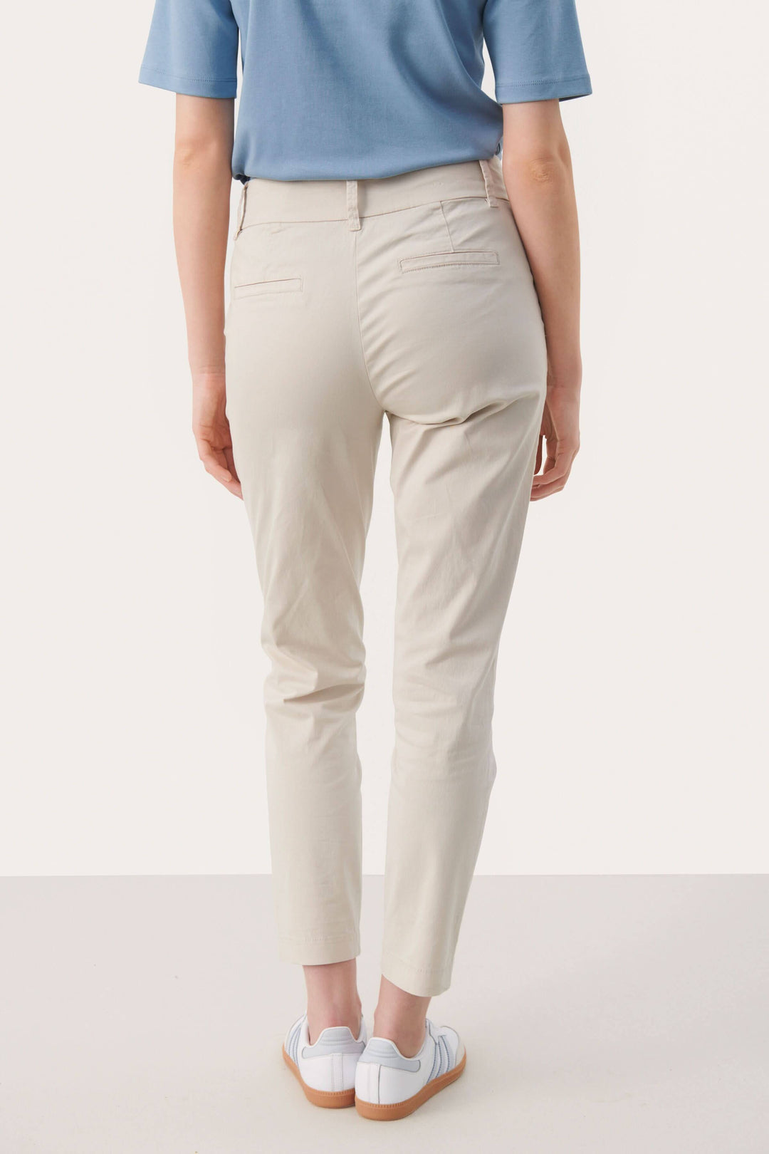 Pantalon chino Soffys vu de dos, coupe droite classique, taille classique, couleur beige, porté avec des baskets blanches.