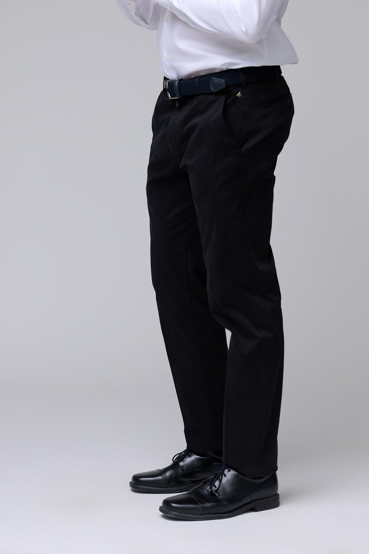 Homme portant un pantalon chino ajusté noir, idéal pour un look professionnel et décontracté avec coupe droite et confort optimal.