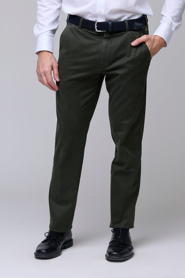Pantalon chino ajusté vert porté avec chemise blanche et chaussures noires, coupe moderne et confortable.