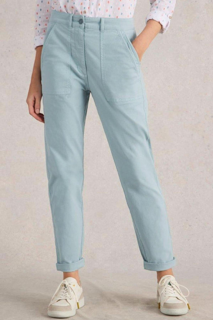 Pantalon chino long Twister bleu clair, coupe droite, poches plaquées, ourlets retroussés, porté avec des souliers blancs.