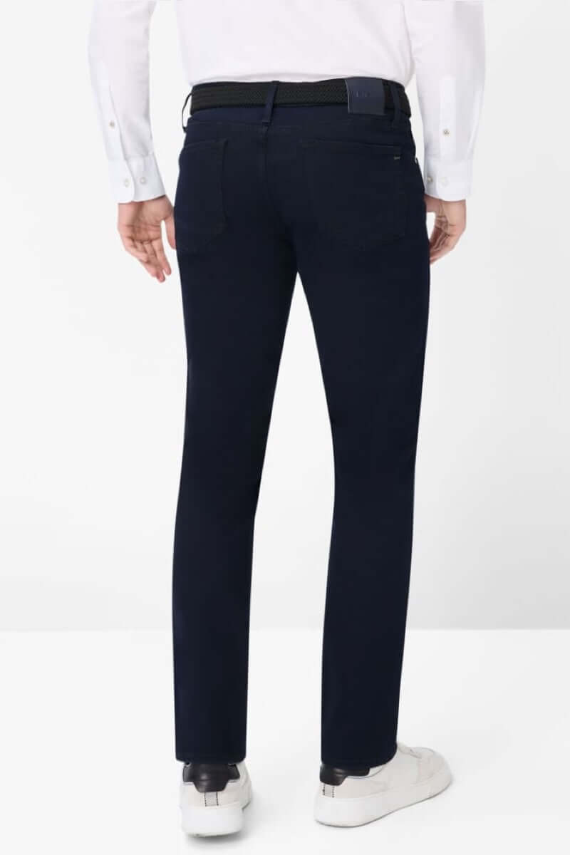 Pantalon cinq poches pour homme, coupe moderne, vue arrière, bleu foncé, porté avec une chemise blanche.