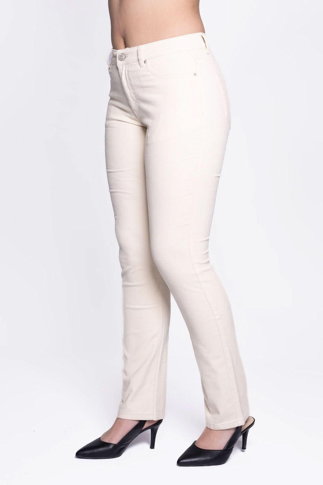 Pantalon à coupe droite blanc en tissu extensible, porté avec des escarpins noirs pour un look élégant et intemporel.