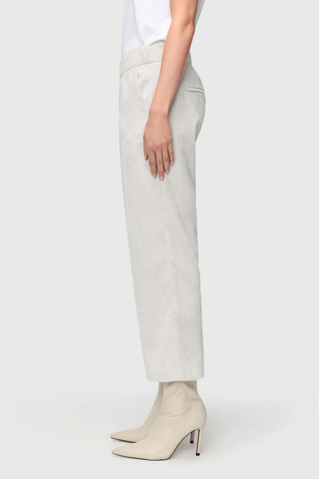 Pantalon court Chiara en velours côtelé, coupe droite, taille élastiquée, porté avec des bottines blanches.
