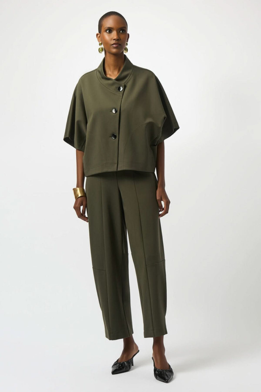 Pantalon de tricot épais et élégant en vert olive, avec haut décontracté et accessoire doré.