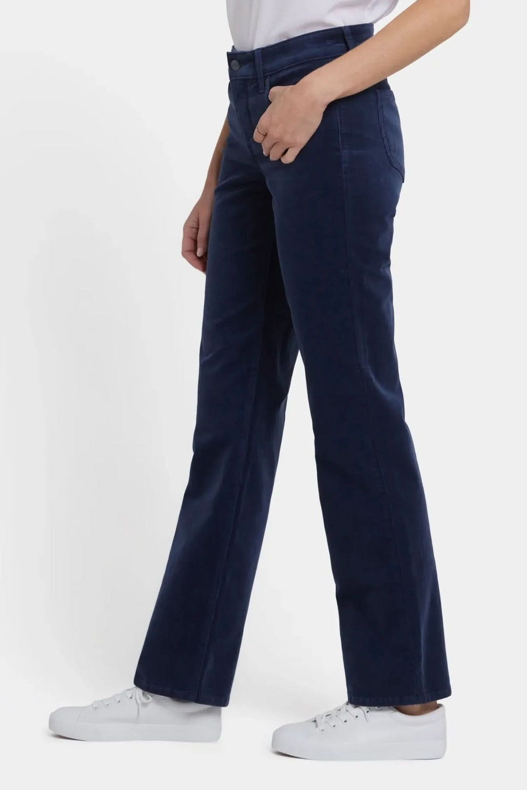 Pantalon droit en velours côtelé extensible bleu pour femme, coupe droite, taille mi-haute, avec chaussures blanches, vue latérale.