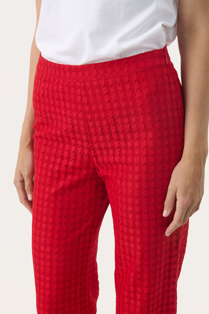 Pantalon en dentelle rouge à motif pied-de-poule, coupe droite et fluide pour un look élégant.