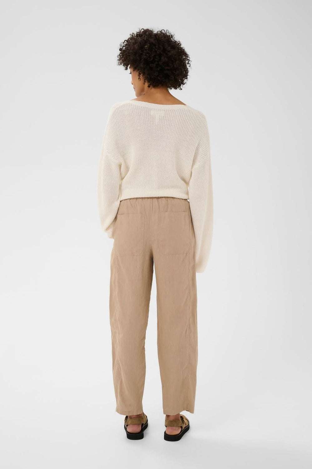 Vue arrière du pantalon en lin Atima beige, coupe droite et tombé souple, porté avec une tenue décontractée.