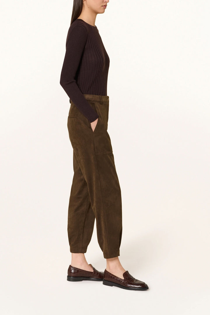 Pantalon en suédine à pinces, femme de profil portant le pantalon élégant et confortable, image décontractée et chic.
