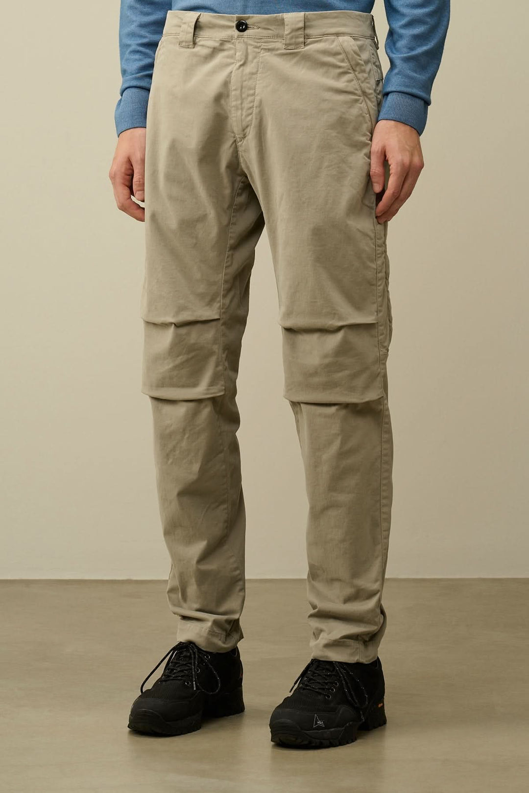 Pantalon ergonomique en satin extensible beige avec poches latérales, fermeture à boutons et à glissière.